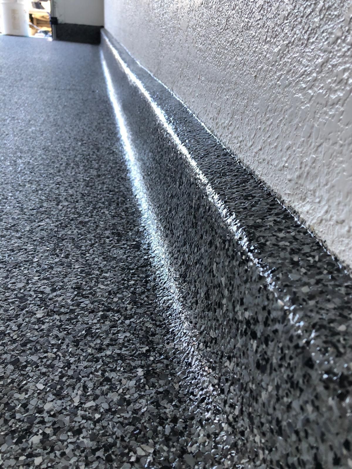 Gray flake epoxy floor in a commercial space with a coved base