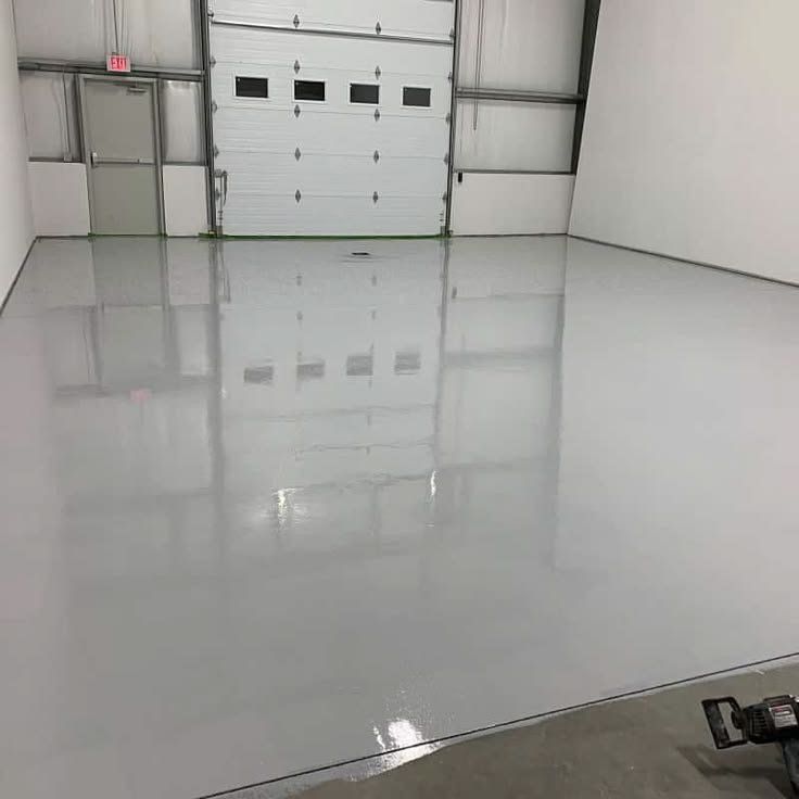 Metal shop garage with a glossy, light-gray solid-color epoxy floor coating