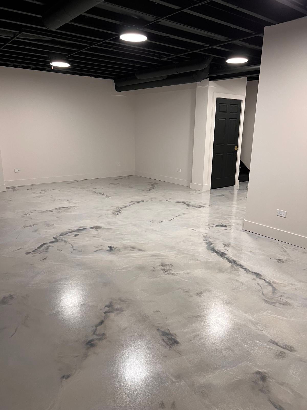 White and gray metallic epoxy basement floor with a marbled, high-gloss finish